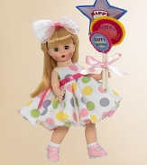She's dressed in the most charming, sleeveless frock that has a full skirt and features delightful pink, green, yellow and blue circles printed on white cotton fabric. A hot pink satin ribbon encircles her waist and accentuates the colored circles on the dress. The dress is worn with white socks and panties, light pink Mary Janes and looks fabulous with the pink ribbon bow and headband that adorns her hair.