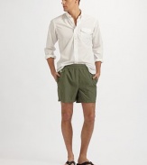 Swim trunk designed in a classic solid print and cut for a shorter, modern fit. Elastic waistband with hidden tie Back waist drainage grommets Logo embroidery Flap coin pocket at the right hip Back flap patch pocket Mesh lining Inseam, about 4¾ Polyester/nylon Machine wash Imported 