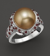Thickly scattered white and brown diamonds frame a golden cultured pearl set in 18K white gold.