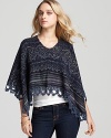 A Free People cape flaunts trend-right Fair Isle with crochet trim and metallic threading--a must-have layering piece for winter's chicest days.