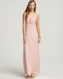 A collection of silk rosettes at the bodice lends rich romantic appeal to this Empire waist gown from Amsale.