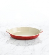 Capture the excellence of French cuisine with a refined dish that features a flat, shallow design and classic scalloped handles. Constructed of cast iron, this piece conducts and retains heat for a savory dish every time. 5-year limited warranty.