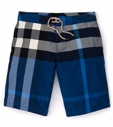 In an allover check print, these iconic swim trunks from Burberry take classic style to the seaside.