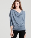 This Eileen Fisher boxy top flaunts a soft, draped neckline and relaxed silhouette that finishes in a cuffed waistband and hem.