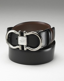 Salvatore Ferragamo Men's Gunmetal Double Gancini Reversible Belt. Classic and sophisticated Double Gancini buckle with Ferragamo engraved on the front and topstitching detailing along the sides. Reversible with double leather closure.