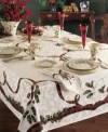 Season's meetings! Traditional holiday motifs of holly and ribbon adorn this durable cotton-blend table cloth. A festive addition to your holiday décor you'll use year after year.