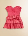 This adorable knit is sweetly gathered on top and wonderfully tiered on the bottom, with wide rows of shimmering ruffles.Smooth jersey top with gathered V necklinePuff sleevesSparkle tiered skirt50% cotton/50% modalHand washMade in USA