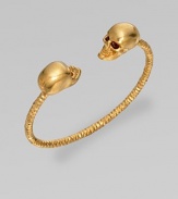 This Swarovski crystal accented design features two goldtone skulls on a textured cuff. Goldtone brassSwarovski crystalsDiameter, about 2½Slip-on styleMade in Italy 