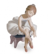 The picture of innocence, a young ballerina prepares for her debut in this darling figurine by Lladro. A white tutu and pink slippers complete the look in meticulously handcrafted porcelain.