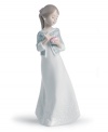 A graceful way of showing you care, this handmade porcelain figurine from Lladro presents a young woman in flowing white with carved detailing upon her dress and sweater wrap.