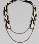 A dramatic look formed of black and white beads in a striking tribal design on a flat strap, framed and finished with bold golden chains.GlassGoldtoneCotton backingLength, about 20¾Imported