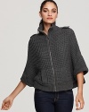 This super cozy layering piece from GUESS fashionably blends the detailing of a chunky-knit sweater with the silhouette of a cape. Makes a unique cardigan too, with the front zipper left open.