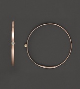 A graceful hoop in yellow gold with diamond accent and invisible closure to create a perfectly elegant orb to complement your most refined ensembles. Designed by Lana.