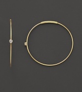 Single diamonds wink from the center of these delicate 14K gold hoops.