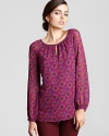 Vibrant florals blossom against a silk Tory Burch top for a fresh, feminine approach to everyday style.
