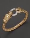 An 18K yellow gold dragon clasps a diamond pavé link in this striking bangle from John Hardy.