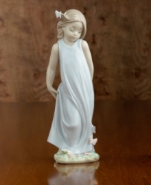 A little girl in a flowing gown crowned with a butterlfy in her hair and on her dress. Porcelain. Measures 8.5 x 3.25.