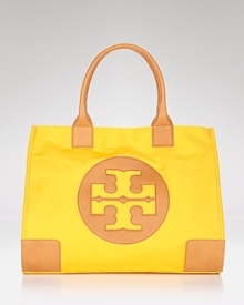 Make Tory Burch's signature coated canvas tote your day-to-day choice. Sized for the essentials, the brightly hued style adds polish to daytime denim and basics. Make Tory Burch's signature coated canvas tote your day-to-day choice. Sized for the essentials, the brightly hued style adds polish to daytime denim and basics.