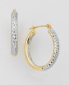 An unique design for classic hoop earrings. Two-tone 14k gold oval-shaped earrings feature a glimmering diamond-cut exterior. Interiors are polished for extra shine.