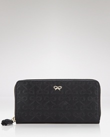 Anya Hindmarch's signature bow logo adorns this luxe leather wallet. Anya Hindmarch's signature bow logo adorns this luxe leather wallet.