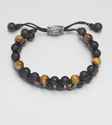 Smooth beaded bracelet of black onyx and tiger's eye with sterling silver lobster clasp.Black onyx/tigers eyeLobster claspAbout 2½ diam.Made in the United Kingdom