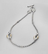A graceful chain is punctuated by bold ovals of 18k gold and lacy silver medallions near the closure. Sterling silver and 18k yellow gold Length, about 18 Toggle closure Made in Greece