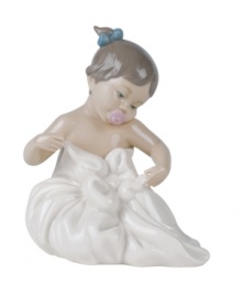 A lasting impression of sheer comfort and contentment, this handmade porcelain figurine depicts a toddler cherishing her first blanket. A lasting impression of sheer comfort and contentment, this handmade porcelain figurine depicts a toddler cherishing her first blanket.