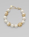 An exquisite strand of pearls accented with 18k gold flower cup caps.14mm round white organic man-made pearls18k goldplated sterling silverLength, about 7½ Lobster clasp closureImported 