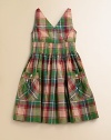 This fun sundress is crafted in preppy madras plaid with pintuck detailing and large patch pockets.V-neckSleeveless cross-front bodiceHidden side zipper with hook-and-eye closureWaist with pintuck detailingLarge patch pockets with button closureFull skirtCottonMachine washImported