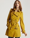 Stand out in rain, wind and fog with this statement trench from Burberry, crafted in a bright yellow hue.