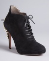 A studded gold-tone plate gives Sam Edelman's basic black suede lace-up bootie edge.