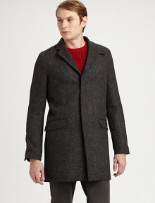 A Japanese wool coat with an elongated silhouette and concealed button closure. Notched collarConcealed button closureFlap pocketsAbout 35 from shoulder to hemWoolDry cleanImported