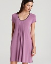 A basic sleeveless chemise with a pleated front and ruffle hem.