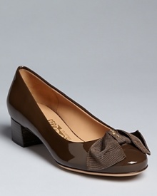 Distinctively shaped grosgrain bows define these Salvatore Ferragamo pumps. Distinctively shaped grosgrain bows define these Salvatore Ferragamo pumps.