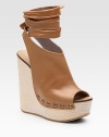 Chic, platform wedge style emboldened by a leather, wrap-around ankle strap. Wooden wedge, 5 Covered platform, 1½ Compares to a 2½ heel Leather upper Peep toe Leather lining Rubber sole Made in ItalyOUR FIT MODEL RECOMMENDS ordering one size up as this style runs small. 