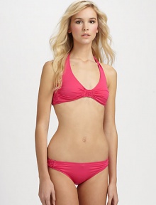 A flattering halter design with pretty gathered details to complement the shape.Halter strap ties at neckRemovable cupsBack tie closureGathered sides92% nylon/8% spandexFully linedHand washImported Please note: Bikini bottom sold separately. 