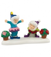 Two little elves jest over who has the best potted plants in this scene from Perry's Christmas Poinsettias shop in North Pole Village. A whimsical figurine from Department 56.
