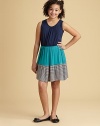 A trendy colorblock detail adds pizazz to this pretty, flowy frock.ScoopneckSleevelessPullover styleElastic waistFull skirtStriped ruffles at hem95% rayon/5% spandexHand washMade in USA