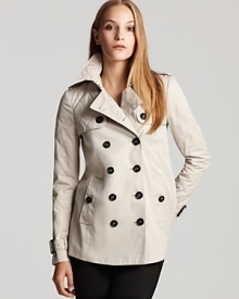 A subtle A-line silhouette and a martingale belt detail at the back waist lend feminine flair to this charming rain jacket from Burberry.