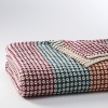 Embellished with a multicolored stripe, this luxurious throw is a chic addition to any home.