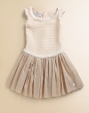 A luxurious and stunning frock of plush cotton and silk with tulle trim and a full, pleated skirt.ScoopneckShort cap sleevesBack zipperFull pleated skirt72% cotton/28% silkMachine washImported
