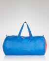 Not your basic weekender: trend-right cobalt and red accents embolden this MARC BY MARC JACOBS duffel bag that packs away for a convenient (and colorful) statement.