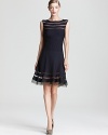 Sheer strips show a subtle peek of skin on this Tadashi Shoji dress, flaunting a flirty flared hem.