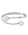 Textured ripples of sterling silver add an edge to the idea of the classic pearl bracelet. This modern Majorica bangle stuns with two lustrous man-made pearls (12 mm). Approximate diameter: 2-1/2 inches.