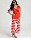 This cute pajama set features a solid short sleeved paired with horizontally striped three-quarter length pants.