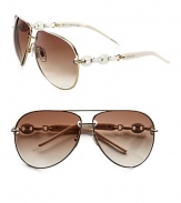 A modern metal frame with decorative chain and logo temples. Available in ruthenium with brown azur gradient lens. Chain and logo temples100% UV protectionMade in Italy 