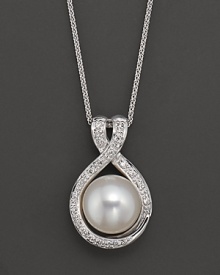 A large freshwater pearl pendant with diamond accents. A large freshwater pearl pendant with diamond accents.