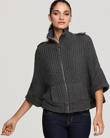 This super cozy layering piece from GUESS fashionably blends the detailing of a chunky-knit sweater with the silhouette of a cape. Makes a unique cardigan too, with the front zipper left open. This super cozy layering piece from GUESS fashionably blends the detailing of a chunky-knit sweater with the silhouette of a cape. Makes a unique cardigan too, with the front zipper left open.
