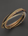 18K gold stations accent a mix of stainless steel cable bangles in black, grey, rose and yellow PVD. From Charriol.