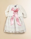 A lightweight layer with heritage charm, a soft cardigan is rendered in a sweet pointelle knit and trimmed with waves of ruffle.Round neckline with single pearlized button closureLong puffed sleevesRuffle trim cuffs and hemCottonHand washImported